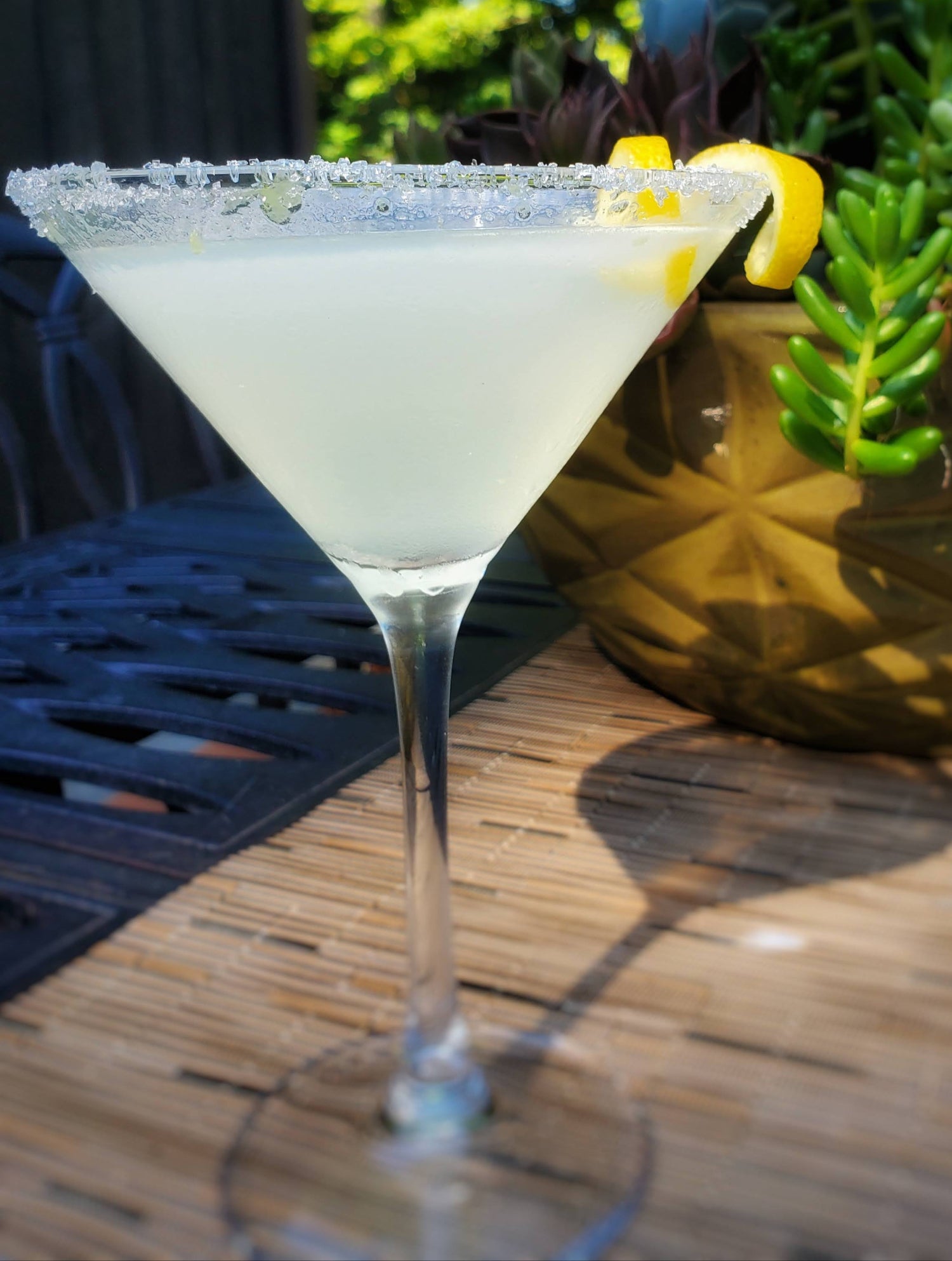 Cocktail in a martini glass with a lemon twist.